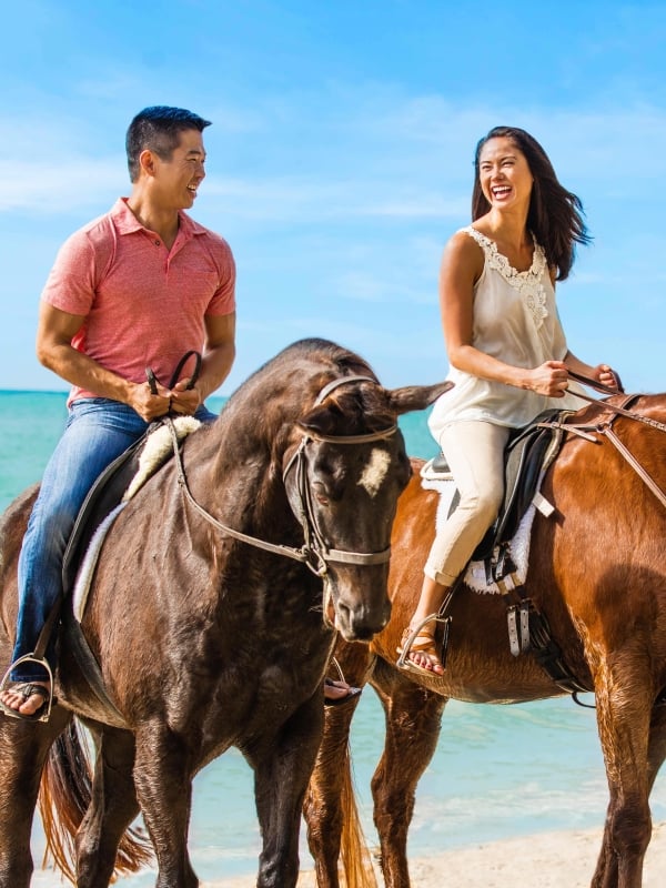A couple riding horses in Nassau