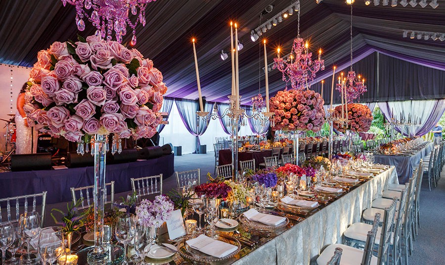 Dramatic table decor, chandeliers and rose bouquets decorate a wedding reception in Nassau Paradise Island, Bahamas