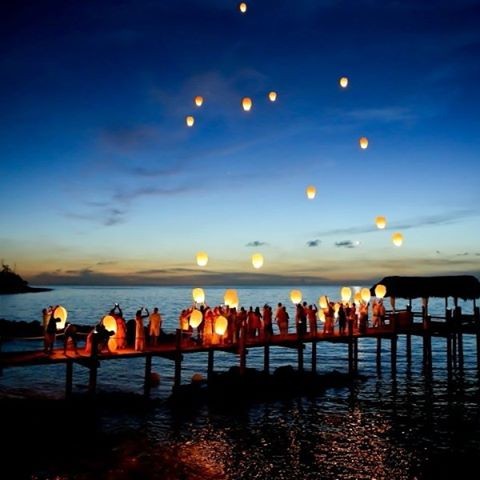 Wedding guests let lanterns float into the clear evening sky at a Bahamas destination wedding. 