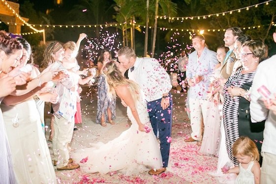 Newlyweds embrace surrounded by loved ones at their Atlantis wedding in the Bahamas