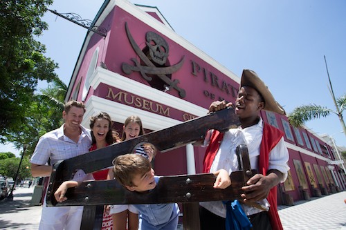 A family and a historical interpreter have fun outside the Pirate of Nassau Museum