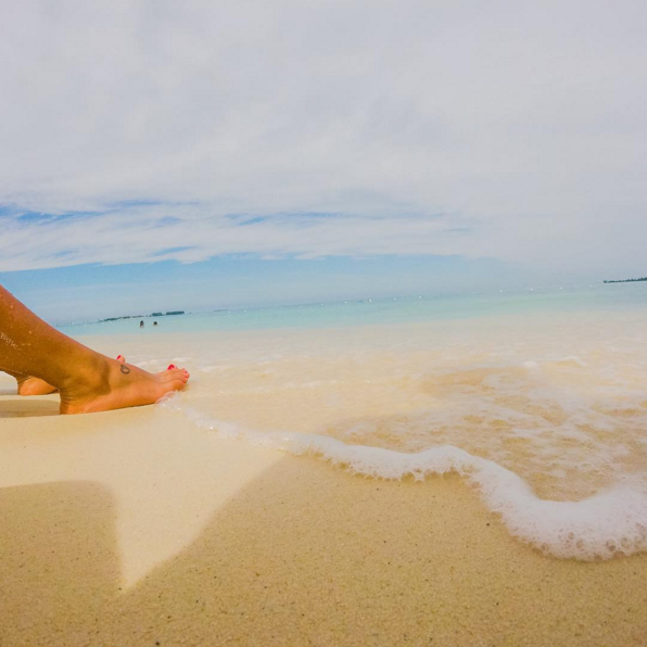 A visitor's bare feet enjoy the warm waves on Cable beach.