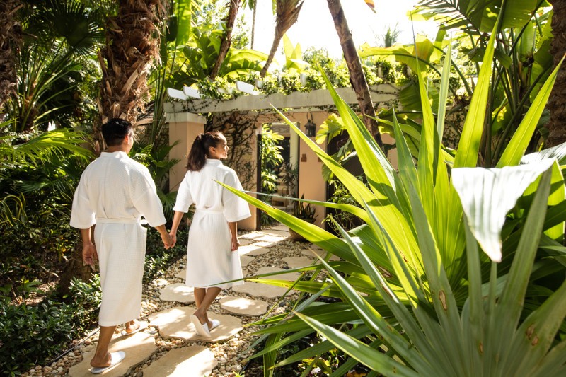 A couple walking in robes outside a spa in Nassau Paradise Island