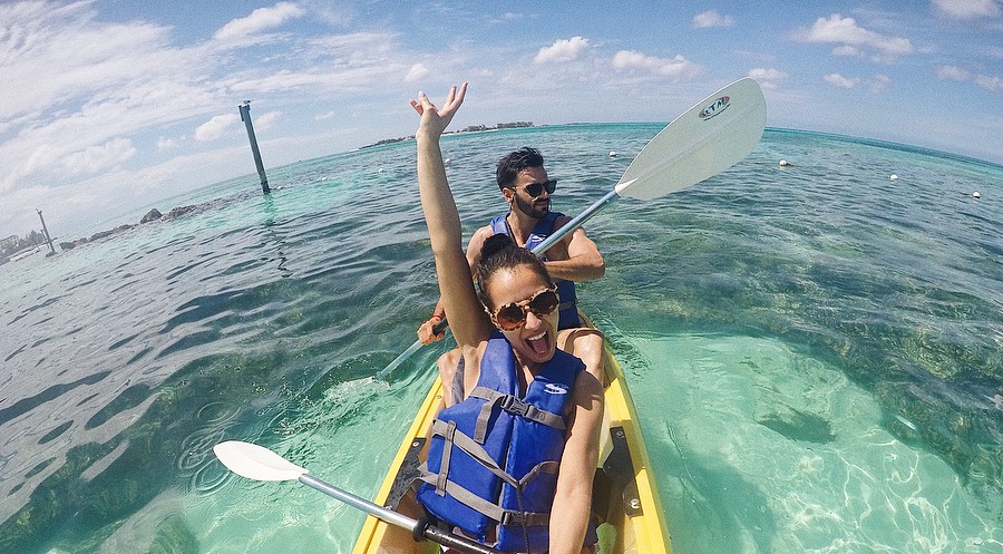 A couple take a selfie while kayaking the crystal clear waters of The Bahamas.
