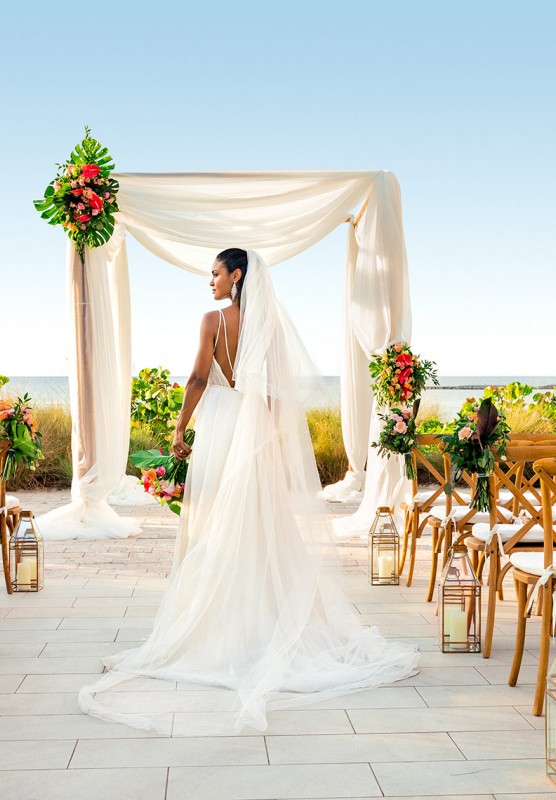 A bride walks down the aisle at her outdoor Bahamian wedding.