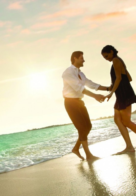 Couple dancing on the beach in front of sunset