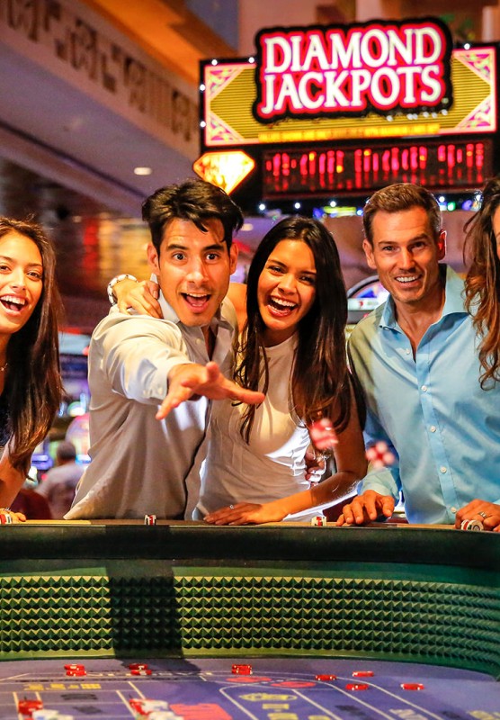 A group of men and women enjoying a game of craps in a casino.