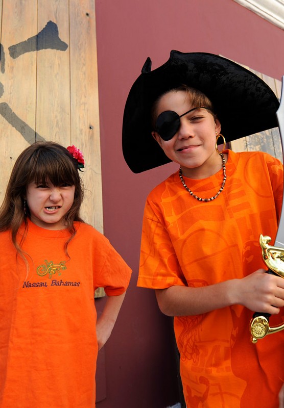 A young girl and a young boy wearing pirate swag outside of the Pirate Museum.