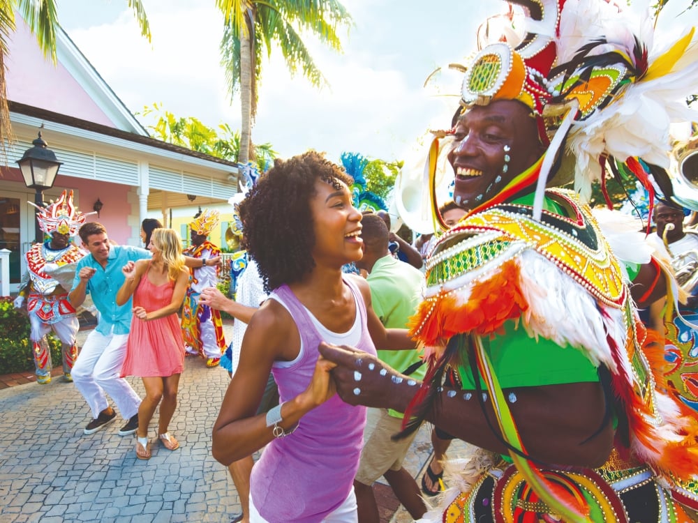 A woman dancing with a Junkanoo dancer