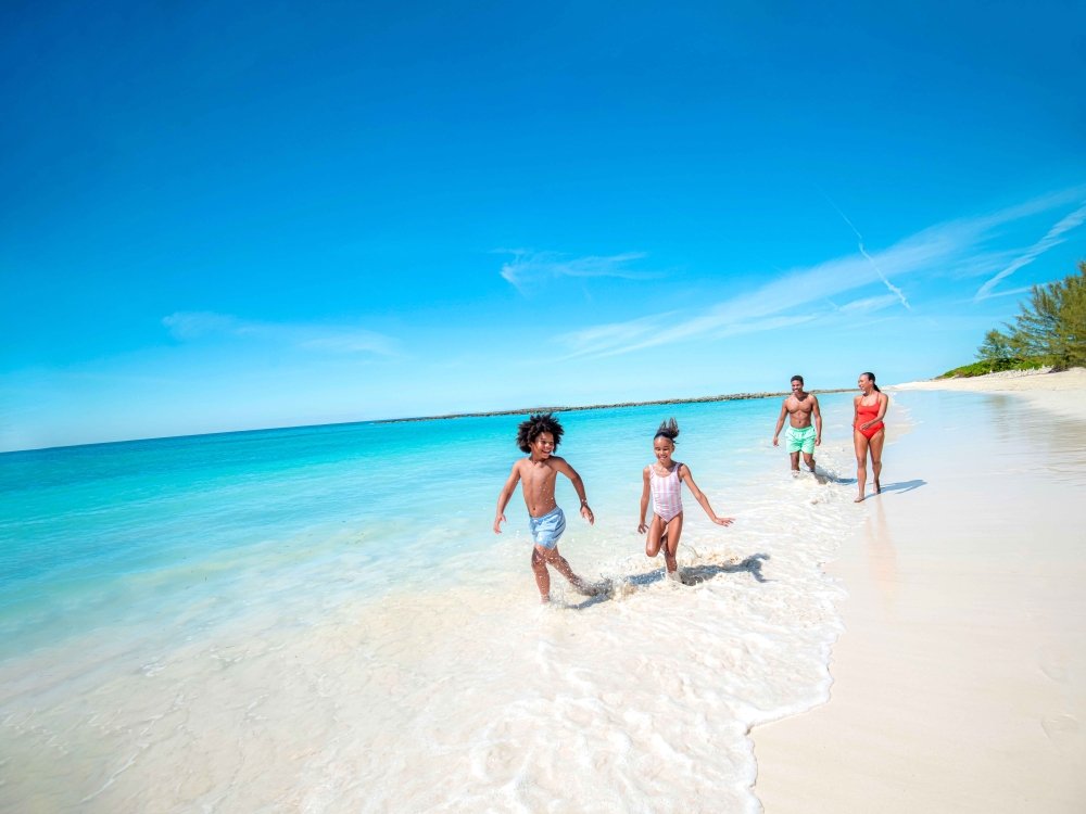 family running along the beach