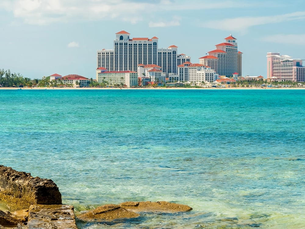 A massive resort rises above a tropical ocean.